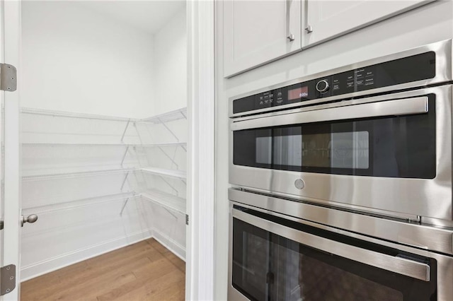 kitchen featuring light countertops, appliances with stainless steel finishes, wall chimney range hood, and visible vents