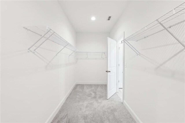 walk in closet featuring visible vents and carpet flooring