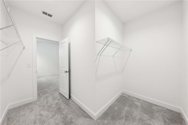 walk in closet with visible vents and carpet