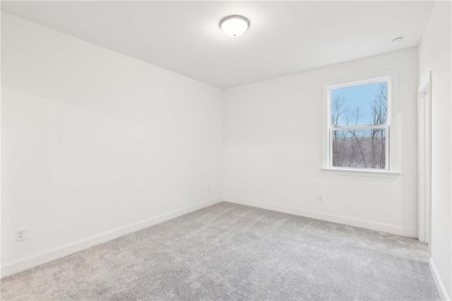 carpeted spare room with baseboards