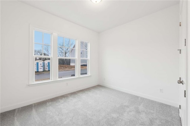 carpeted spare room featuring baseboards
