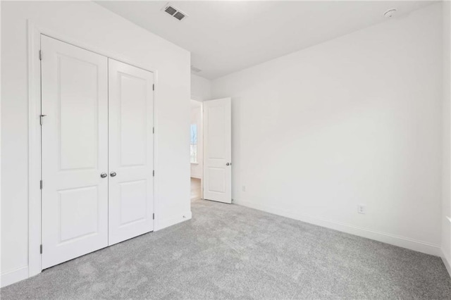 unfurnished bedroom featuring light colored carpet and baseboards