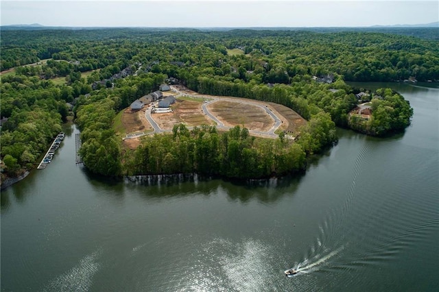 drone / aerial view featuring a forest view and a water view