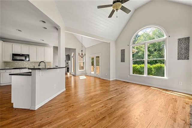 4440 Green Summers Dr, Cumming, GA 30028 - kitchen with black microwave, dark countertops, ceiling fan, white cabinets, and a chandelier