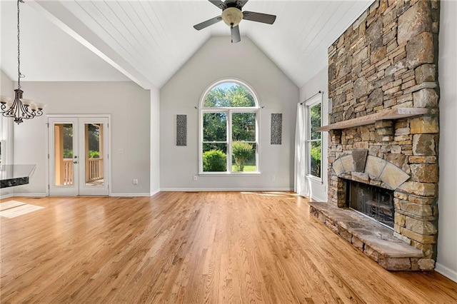 4440 Green Summers Dr, Cumming, GA 30028 - unfurnished living room featuring light wood finished floors, a ceiling fan, a stone fireplace, lofted ceiling, and a chandelier