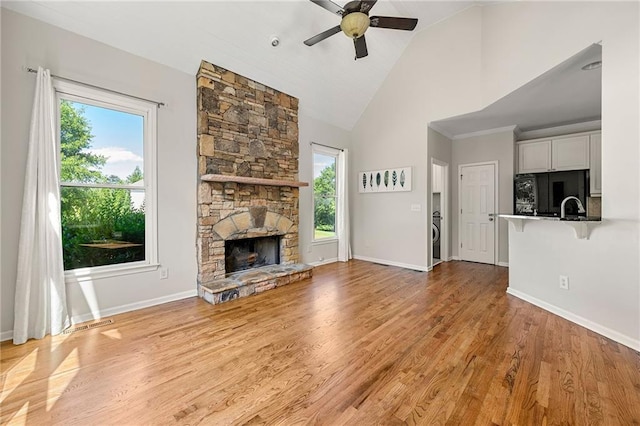 4440 Green Summers Dr, Cumming, GA 30028 - unfurnished living room featuring a ceiling fan, healthy amount of natural light, high vaulted ceiling, baseboards, and a stone fireplace