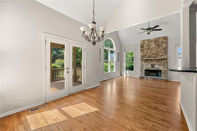 4440 Green Summers Dr, Cumming, GA 30028 - unfurnished living room with french doors, light wood finished floors, high vaulted ceiling, a stone fireplace, and baseboards