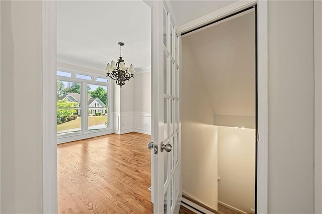4440 Green Summers Dr, Cumming, GA 30028 - hallway with a chandelier, ornamental molding, wood finished floors, wainscoting, and a baseboard radiator