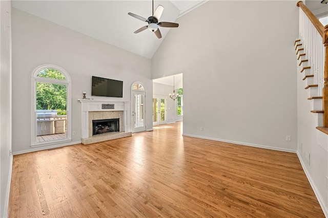 4440 Green Summers Dr, Cumming, GA 30028 - unfurnished living room with healthy amount of natural light, a ceiling fan, a fireplace, light wood-style floors, and high vaulted ceiling