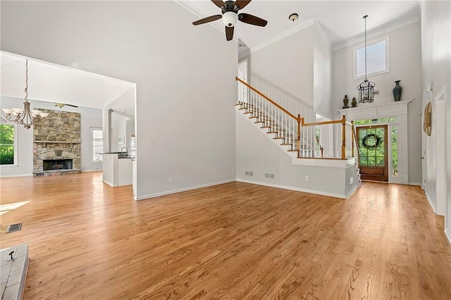 4440 Green Summers Dr, Cumming, GA 30028 - unfurnished living room featuring a towering ceiling, a ceiling fan, healthy amount of natural light, light wood finished floors, and stairway