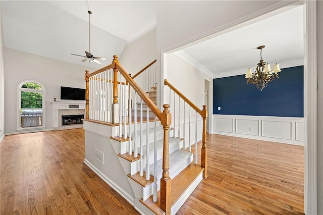 4440 Green Summers Dr, Cumming, GA 30028 - stairs with ceiling fan, crown molding, a chandelier, wood finished floors, and a fireplace