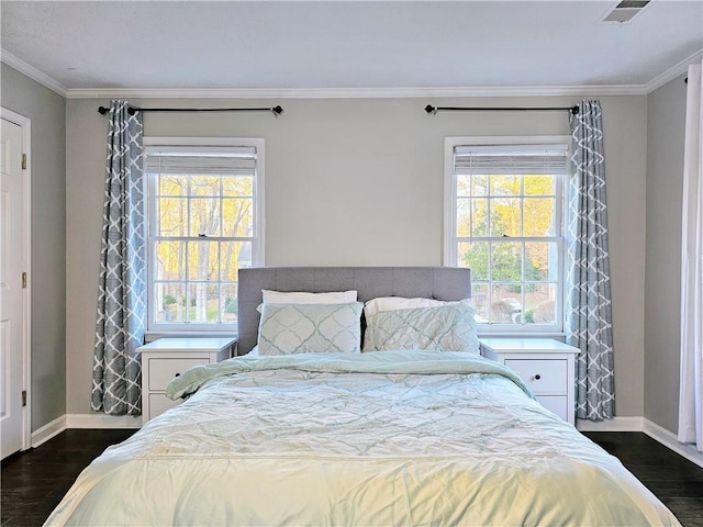 bedroom featuring visible vents, multiple windows, ornamental molding, and dark wood finished floors