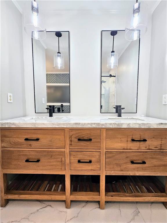 full bath featuring a sink, marble finish floor, double vanity, and crown molding