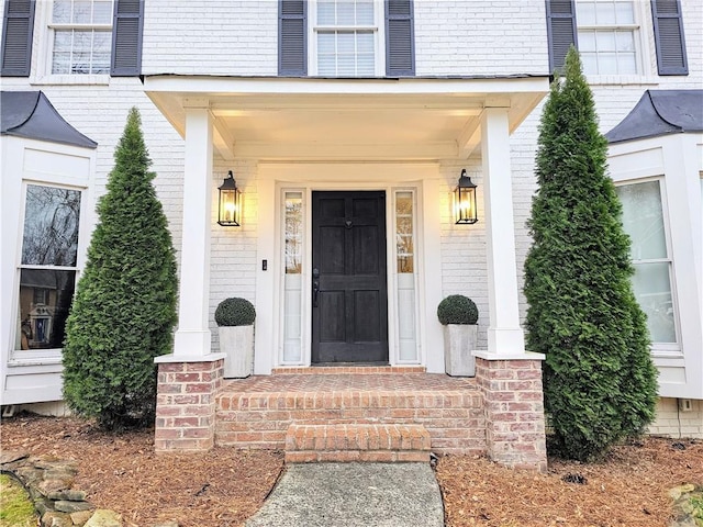 doorway to property featuring brick siding