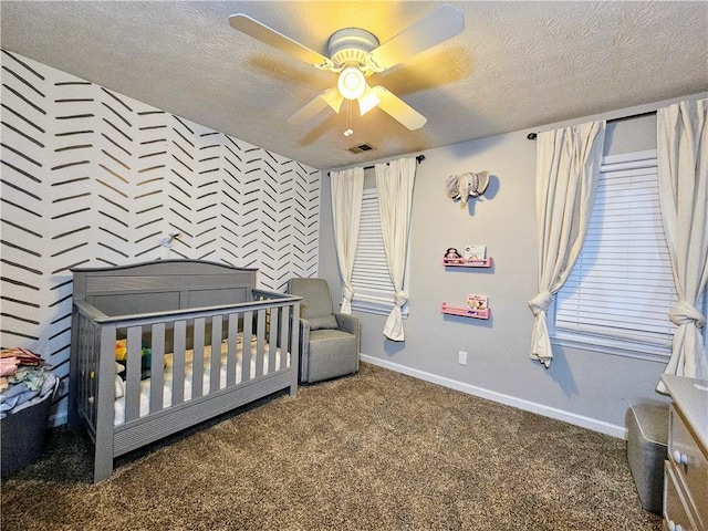 bedroom featuring an accent wall, carpet flooring, visible vents, and a textured ceiling