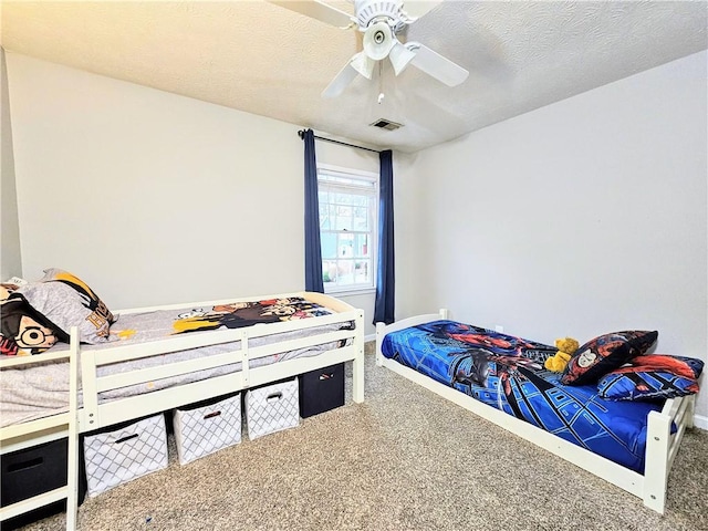 bedroom featuring a ceiling fan, baseboards, visible vents, carpet floors, and a textured ceiling