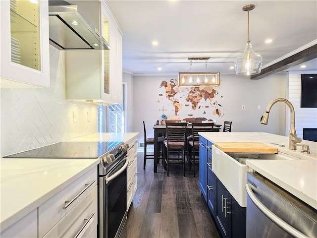 kitchen featuring stainless steel appliances, exhaust hood, white cabinets, light countertops, and glass insert cabinets