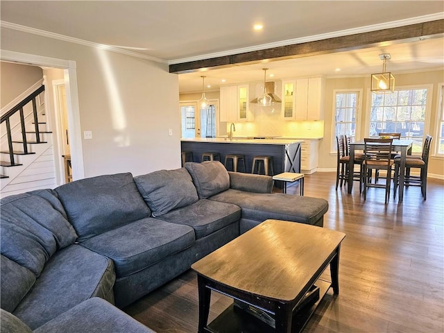 living room featuring dark wood-style floors, stairs, and ornamental molding