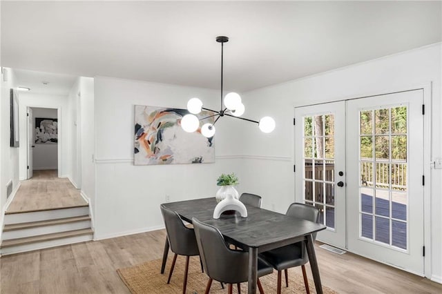 dining space featuring french doors, light wood-type flooring, and visible vents