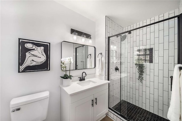 bathroom featuring a stall shower, vanity, and toilet