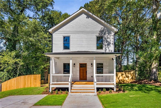 view of front facade with fence, a front lawn, and a porch