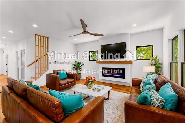 living area with ceiling fan, wood finished floors, stairs, a fireplace, and recessed lighting