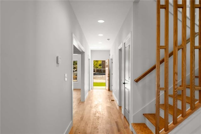 hall featuring stairs, light wood finished floors, baseboards, and recessed lighting