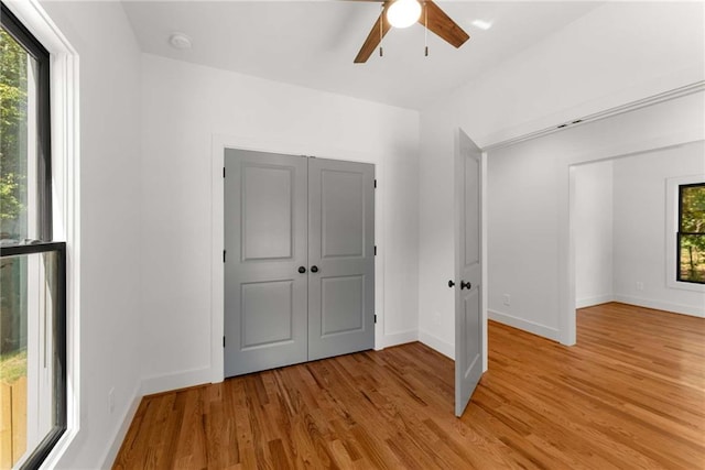 unfurnished bedroom with light wood finished floors, ceiling fan, and baseboards