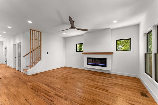 unfurnished living room with light wood finished floors, plenty of natural light, visible vents, and recessed lighting