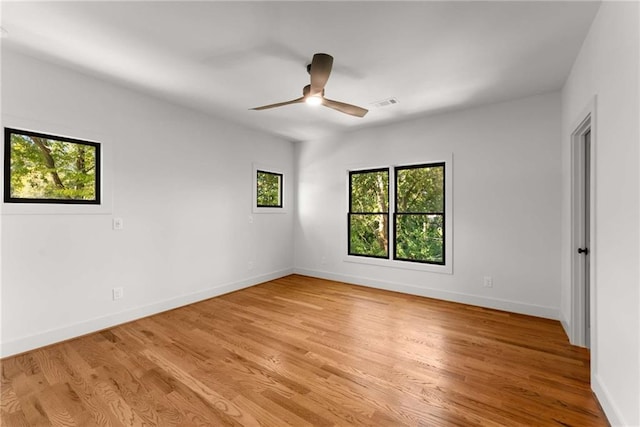 unfurnished room featuring visible vents, ceiling fan, light wood-style flooring, and baseboards