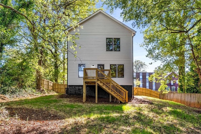 back of house featuring stairs and a fenced backyard