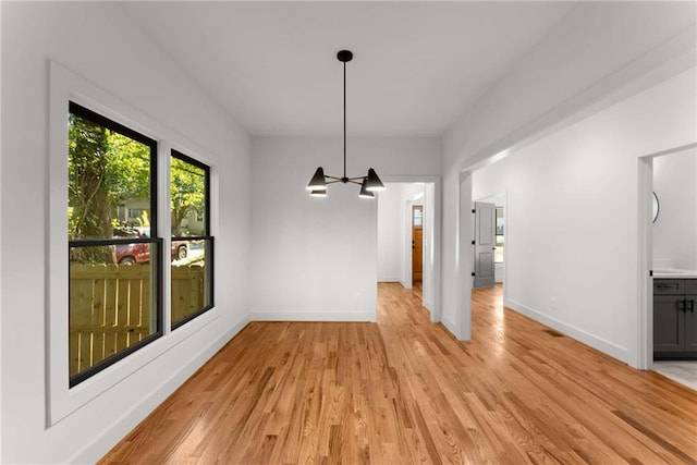 unfurnished dining area featuring light wood finished floors and baseboards