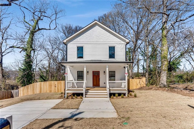 view of front of property featuring covered porch, fence, and a gate