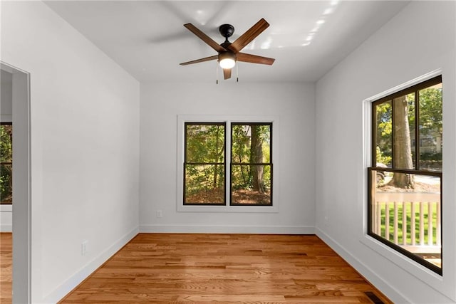 empty room featuring visible vents, ceiling fan, baseboards, and wood finished floors