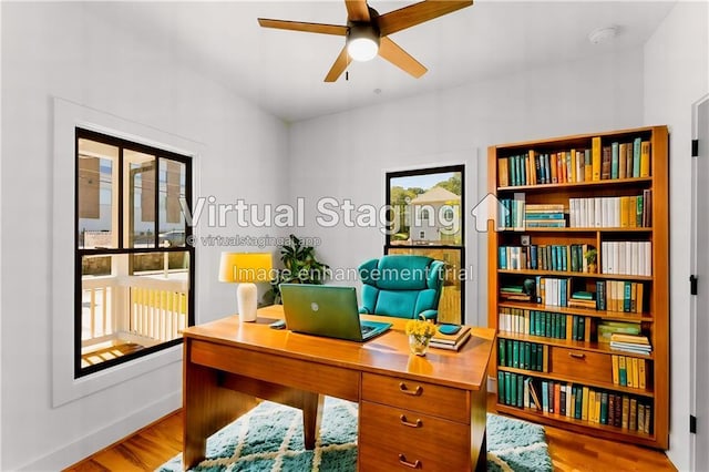 office space with baseboards, a ceiling fan, and wood finished floors