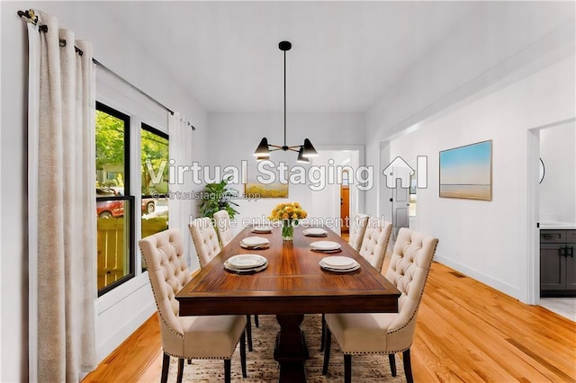 dining area with baseboards, visible vents, and light wood finished floors