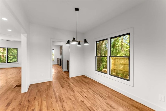 unfurnished dining area with baseboards, recessed lighting, and light wood-style floors