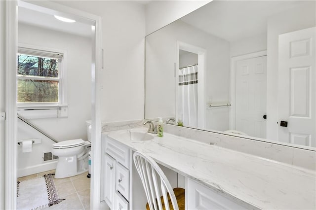 bathroom with tile patterned flooring, vanity, and toilet