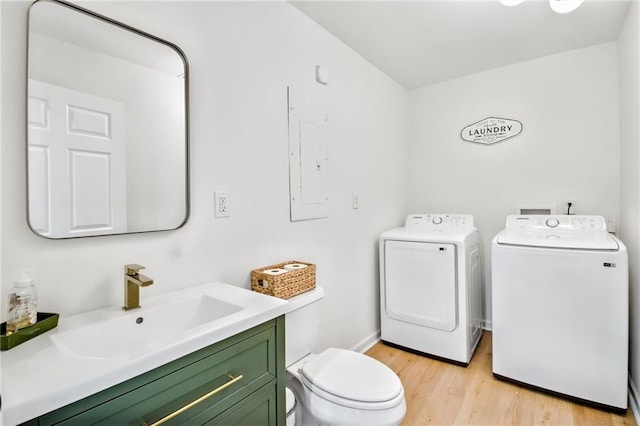 bathroom featuring toilet, washer and clothes dryer, vanity, and hardwood / wood-style floors