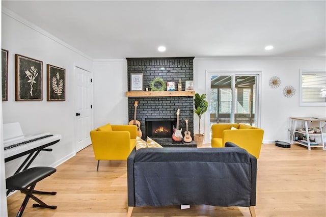 living room with hardwood / wood-style flooring, a brick fireplace, and crown molding