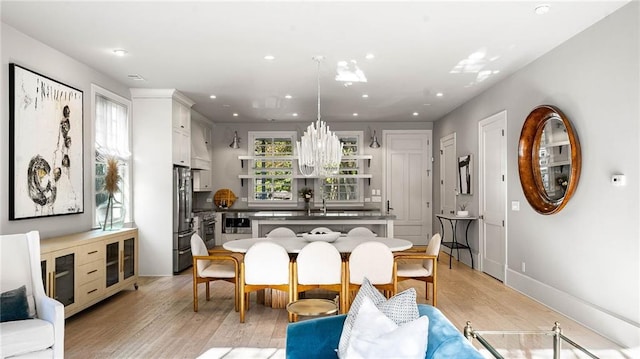 dining space featuring sink, light hardwood / wood-style flooring, and plenty of natural light