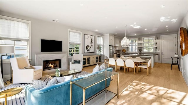 living room featuring sink, light hardwood / wood-style flooring, and a wealth of natural light