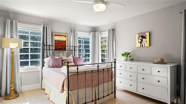 bedroom with light hardwood / wood-style flooring, multiple windows, and ceiling fan