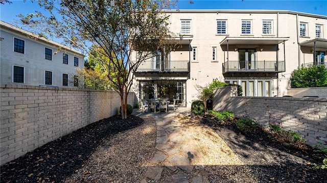 rear view of house with a patio and a balcony