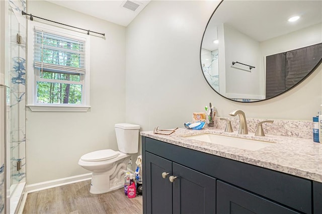 225 Hardwood Dr, Covington, GA 30016 - bathroom featuring wood finished floors, vanity, toilet, a shower stall, and baseboards