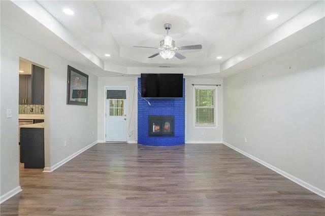 225 Hardwood Dr, Covington, GA 30016 - unfurnished living room with a ceiling fan, a raised ceiling, wood finished floors, baseboards, and recessed lighting
