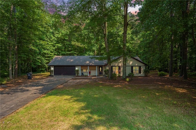 225 Hardwood Dr, Covington, GA 30016 - view of front facade featuring asphalt driveway, a front lawn, a porch, and a view of trees