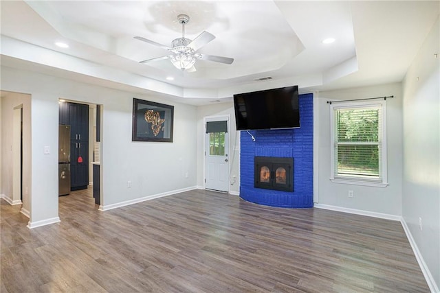 225 Hardwood Dr, Covington, GA 30016 - unfurnished living room featuring a raised ceiling, a ceiling fan, plenty of natural light, baseboards, and recessed lighting