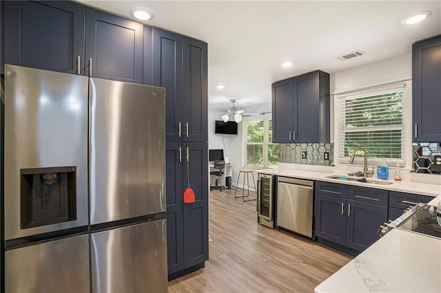 225 Hardwood Dr, Covington, GA 30016 - kitchen featuring appliances with stainless steel finishes, a sink, tasteful backsplash, light countertops, and recessed lighting