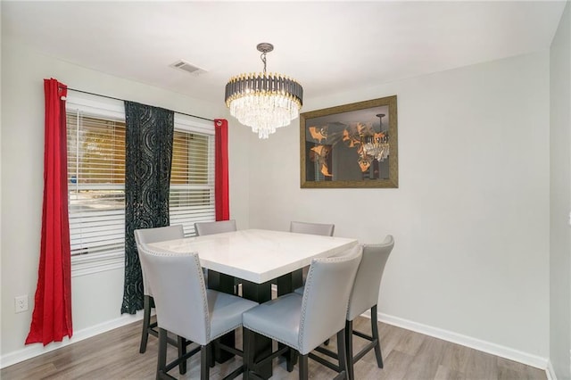 225 Hardwood Dr, Covington, GA 30016 - dining space with light wood finished floors, a chandelier, and baseboards
